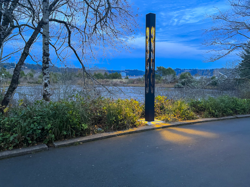 Lit Column By The Water At Dusk
