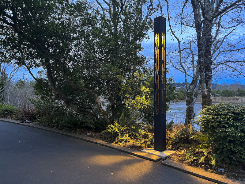 Lit Column By The Water At Dusk