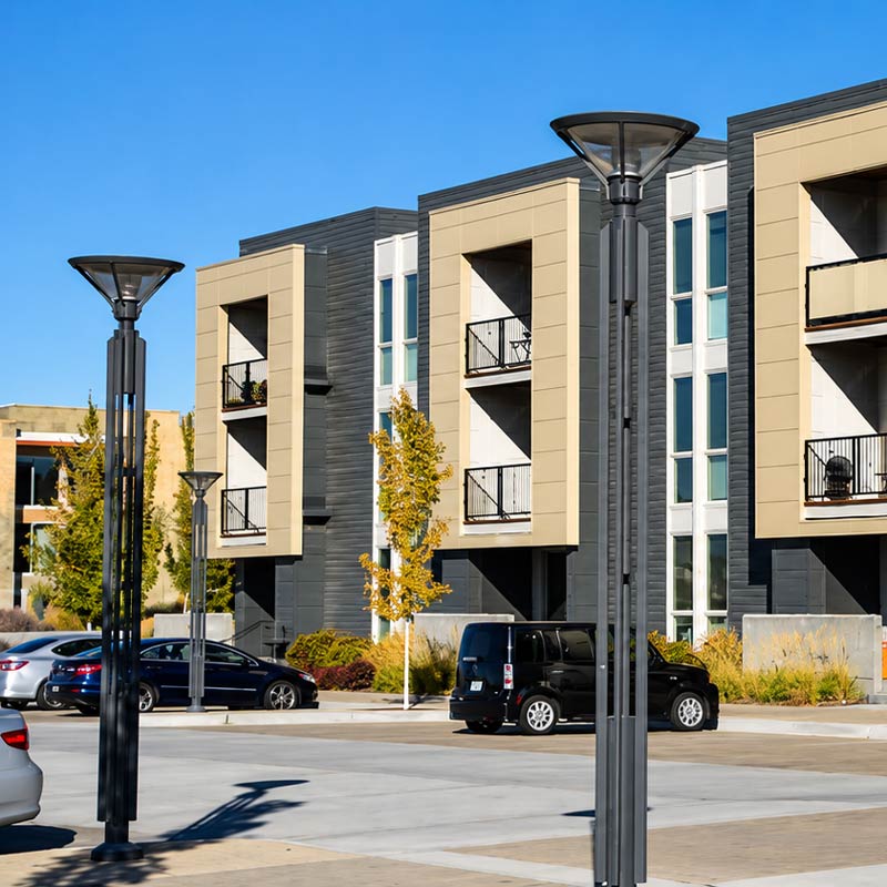 Street and Area Post top streetlamps stand in a parking lot outside of an apartment building